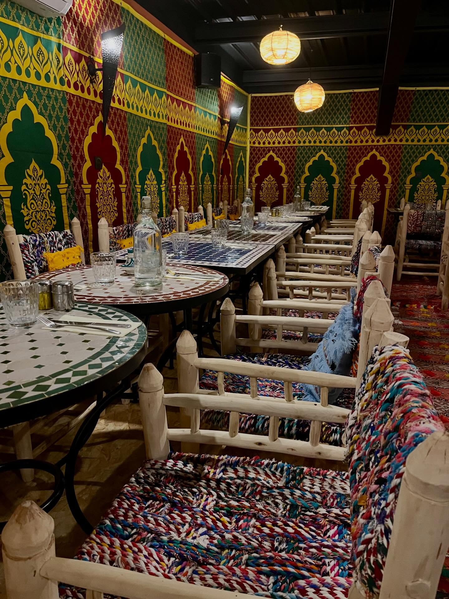 Salle du restaurant aux murs colorés et tables en mosaïque